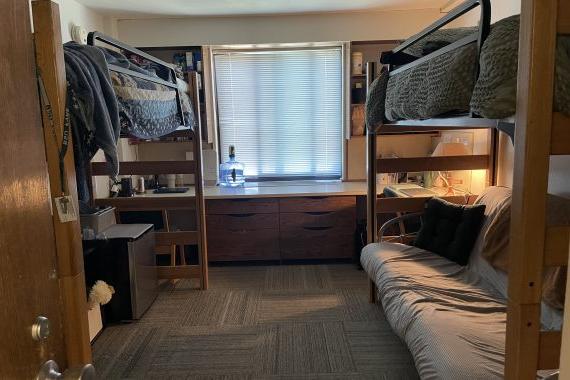 Tamarack double room looking in from the hallway. Each bed is lofted. One has a futon underneath and the other a mini refrigerator and storage container.