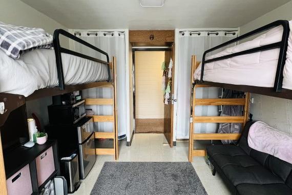 Tamarack double room with two lofted beds. Both closets have matching curtains and the door is open looking into the hallway.